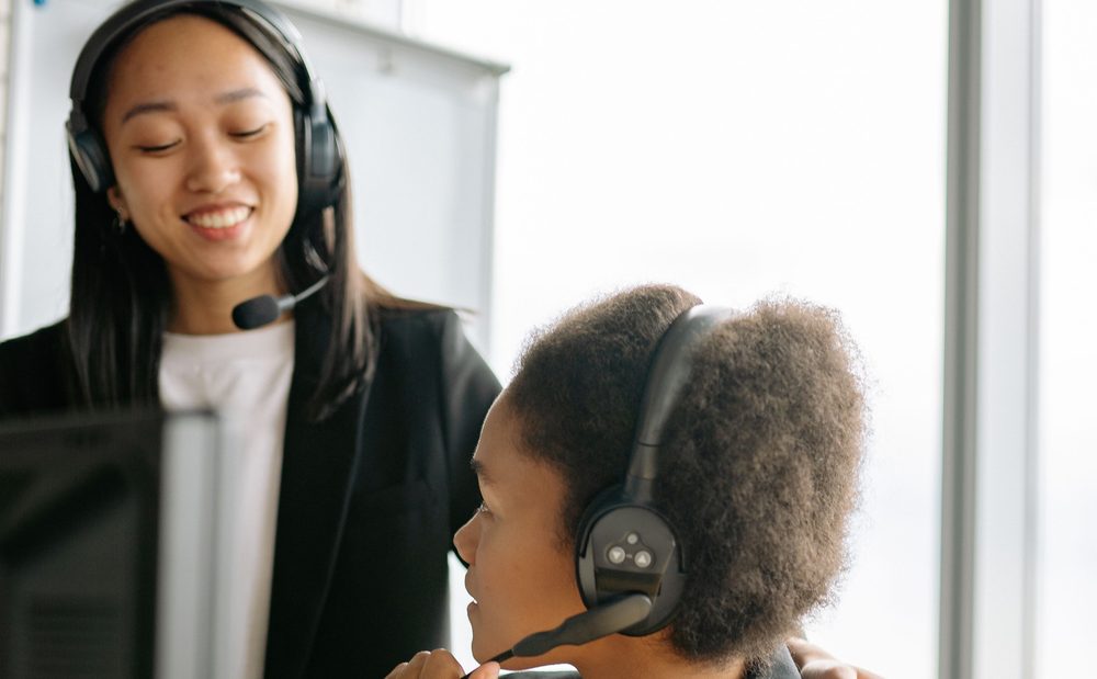 New rep being supported by a teammate at their desk